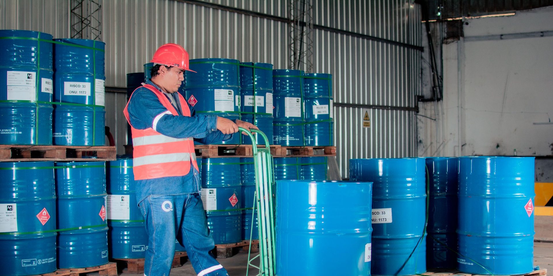Labeled chemical drums stored on pallets in an industrial warehouse